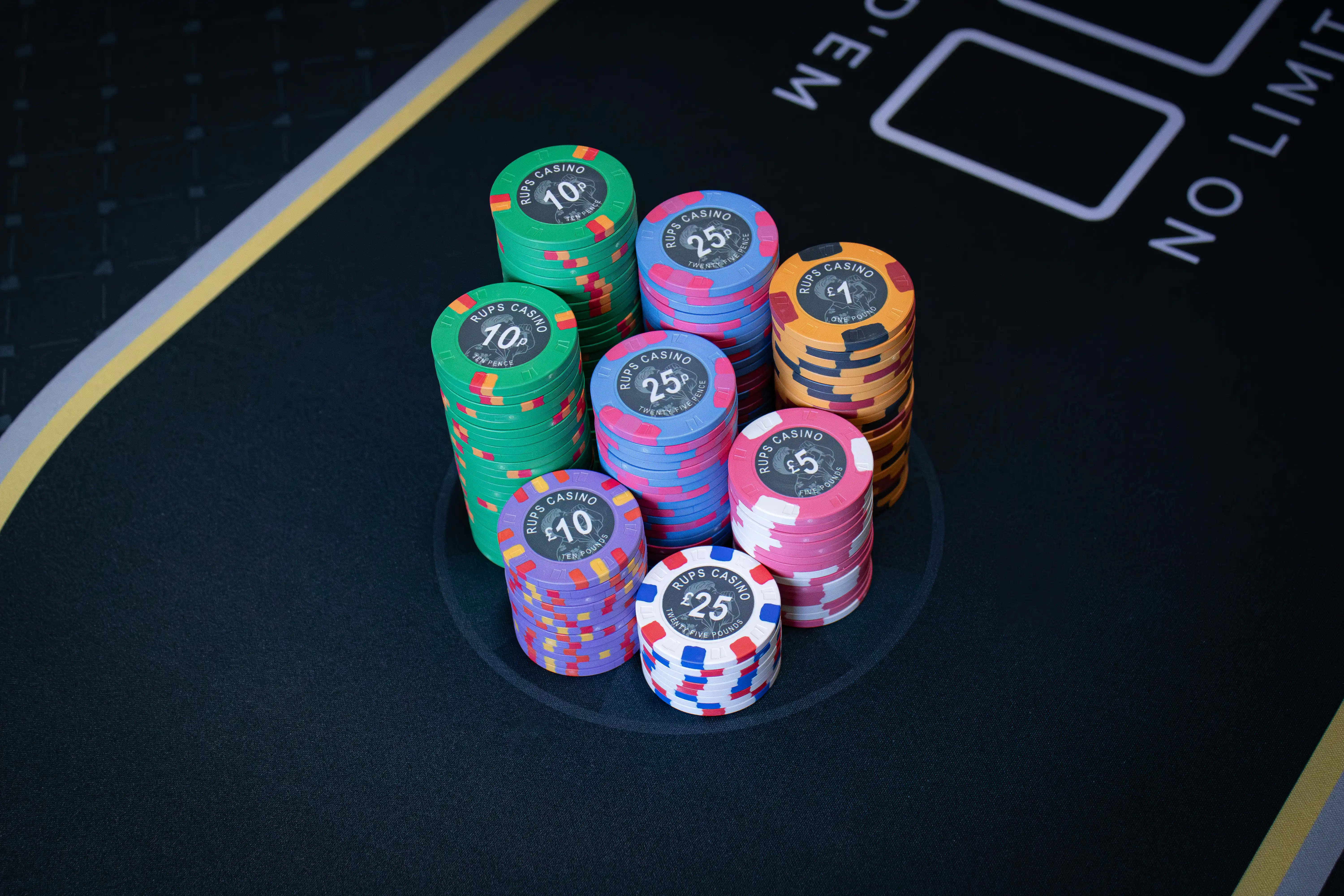 Selection of RUPS Casino custom ceramic poker chips showing multiple denominations and the photo-inspired artwork