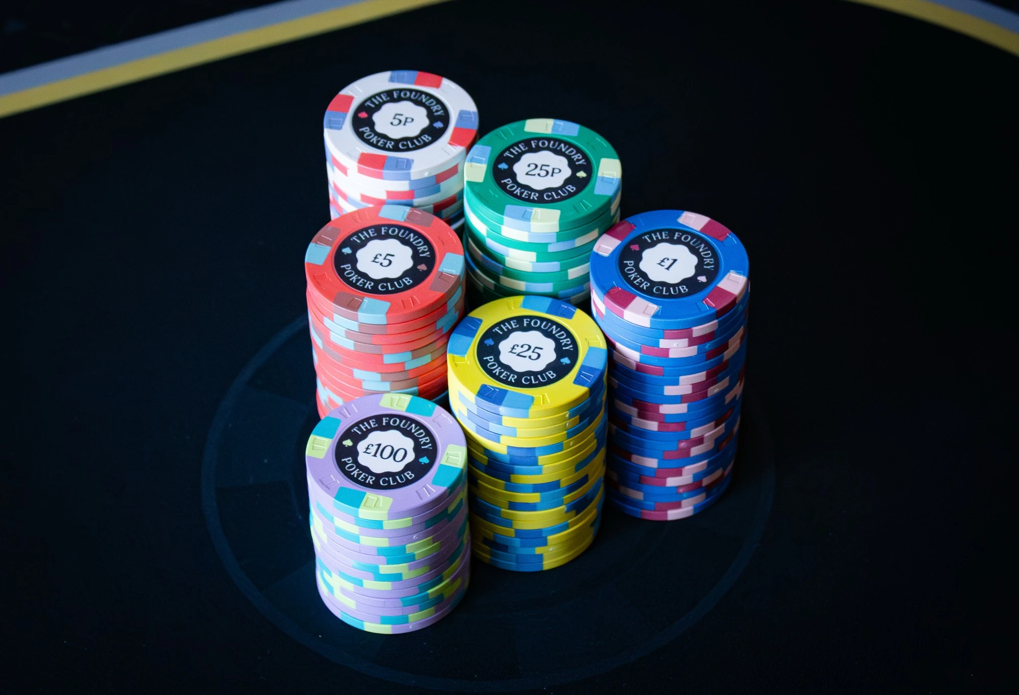 Stacks of The Foundry in-stock ceramic poker chips arranged by sterling denomination